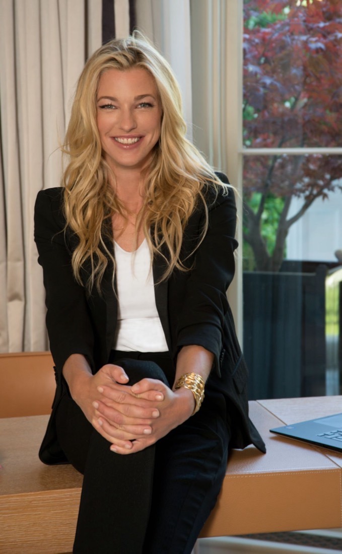 Nicole Junkerman sorride alla sua scrivania accanto a una finestra